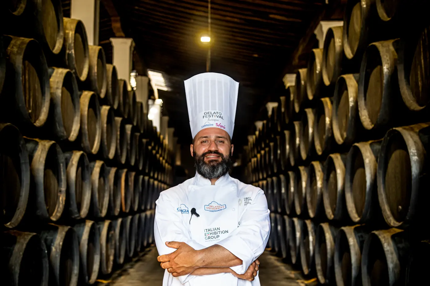 Carlo in giacca da chef tra le botti di una cantina di Jerez