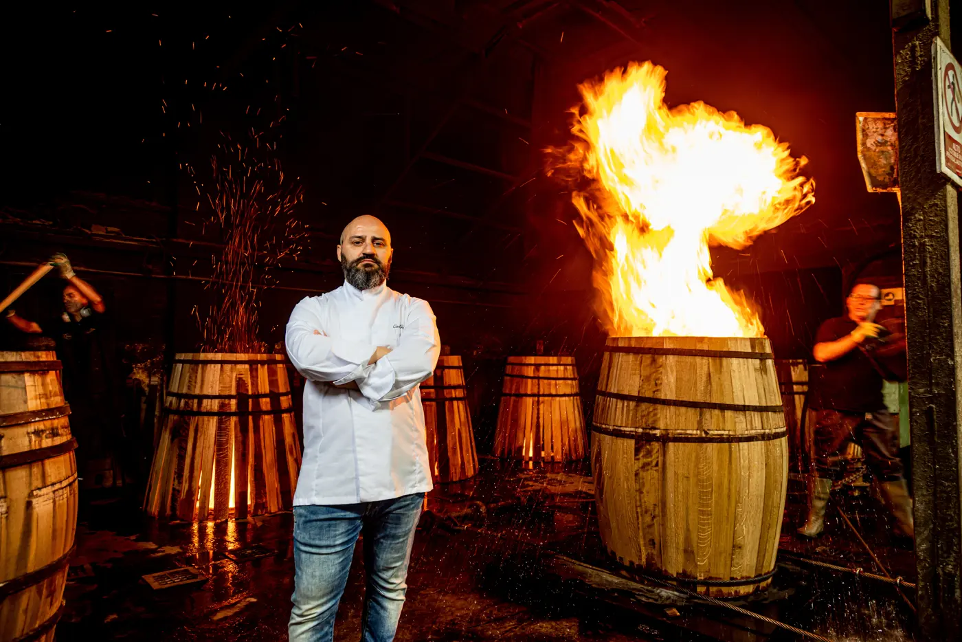 Carlo tra le botti, con le fiamme alle spalle